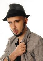 close up portrait of young sexy man in hat and jacket looking aside photo