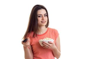 Cutie brunette smiling with tv remote and pop-corn photo