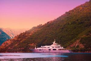 photo of yacht on the sea at sunset