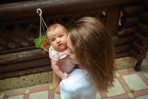 charming young mother with little baby girl in hands photo