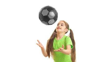 niña alegre juega con la pelota en el estudio foto