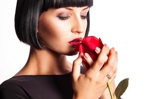 Horizontal portrait of brunette with red rose on white background photo