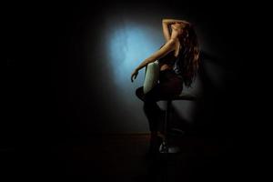 hermosa dama con peinado rizado en estudio oscuro foto