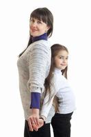 vertical portrait of a young mom that stands in the Studio with her daughter photo