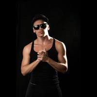 square picture of artist in sunglasses and shirt on black background photo