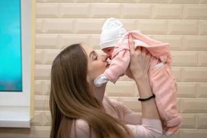 linda mamá con una pequeña hija recién nacida foto