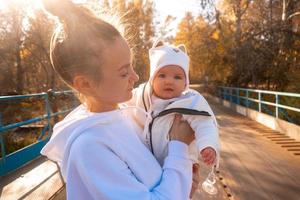 beautiful young mom with baby in autumn photo