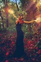 amazing young witch casts a spell in the woods photo