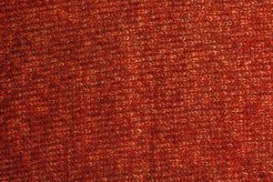 Knitted fabric textured background. Knitting. Colorful red-orange knitted pattern. Red yarn. photo