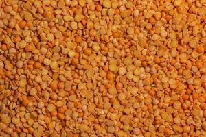 Background of the raw yellow variety of the split peas on a wooden surface, top view photo