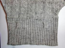 Gray knitted handmade sweater background. The texture of the surface of the woolen jersey made of yarn, close-up. Image for the background. Wool carpet or sweater. Gray texture. Modern design. photo