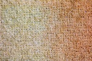 Knitted wool textile textured background in light beige creamy brown shade. Beige color gradient on texture background. photo