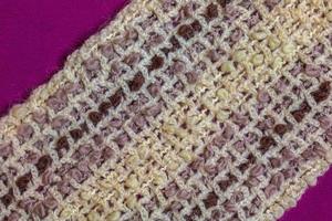 Warm beige woolen scarf on a lilac-burgundy background photo