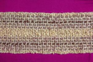 Warm beige woolen scarf on a lilac-burgundy background photo