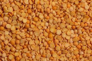 Background of the raw yellow variety of the split peas on a wooden surface, top view photo