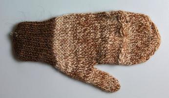 Handmade brown-beige mittens from Argentinean merino wool on a white background. photo