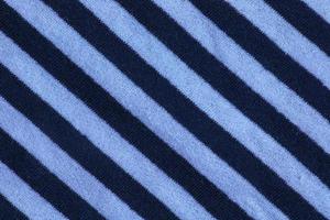 textura textil marina para el fondo. primer plano de una textura textil marina con rayas diagonales azules y blancas. foto