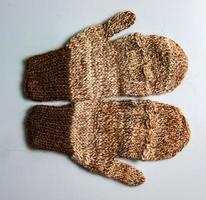 Handmade brown-beige mittens from Argentinean merino wool on a white background. photo