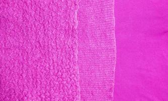 primer plano de alfombra de punto rosa lila. textura textil sobre un fondo rosa lila. fondo detallado de hilo cálido. tejido de lana natural, fragmento de suéter. foto