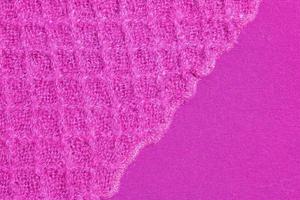 Lilac-pink knitted carpet close-up. Textile texture on a lilac-pink background. Detailed warm yarn background. Natural wool fabric, sweater fragment. photo