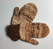 Handmade brown-beige mittens from Argentinean merino wool on a white background. photo