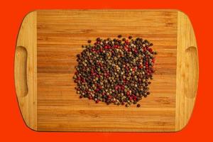 Wooden food background with spices. A mixture of peppers on a kitchen board. photo