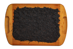 Black sesame seeds on a wooden kitchen board. Healthy food concept. png