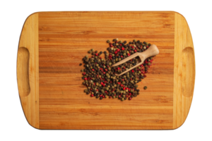 Wooden food background with spices. A mixture of peppers with a wooden spoon on a kitchen board.