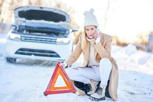 Woman with broken car during winter photo