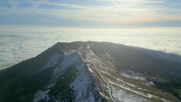 hermoso paisaje con montañas y nubes de niebla, drones volando alrededor de la cima de la montaña video