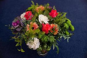 ramo florístico de gerberas rojas, claveles y vegetación foto