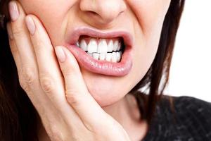 Woman with a toothpain, isolated on white background photo