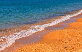 playa. arena amarilla y agua azul foto
