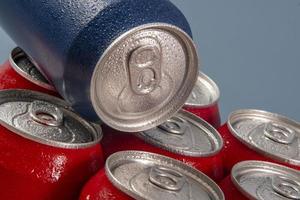 Cold red soda cans with a blue one for conceptual use photo