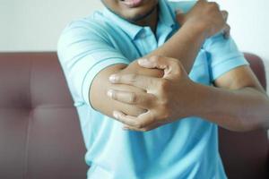 young man suffering pain on elbow photo