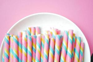 colorful wafer roll chocolate on pink background photo