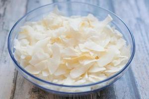 slice of fresh coconut flakes in a bowl on a table photo