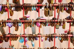 Many love padlocks locked on rusty iron gate in singapore photo