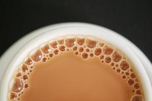 primer plano de una taza de té con leche en la mesa foto