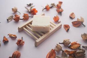 Homemade natural soap bar and dry flower on black background photo