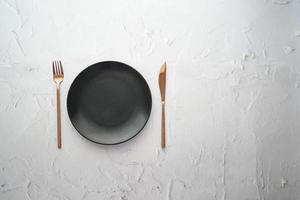 cutlery and empty plate on wooden background top down photo