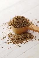 cumin seeds on spoon on table , close up photo