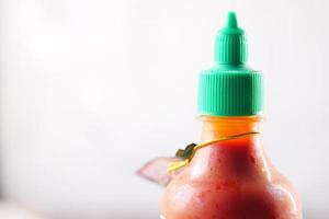 chili and tomato sauce in a small jar on table photo