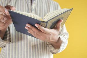 muslim man hand holding Holy book Quran with copy space photo