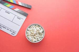 Movie clapper board and popcorn on table top view photo