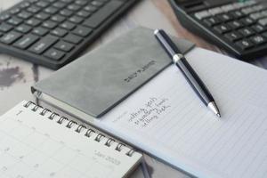 weekly planner and notepad on table photo