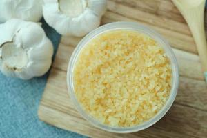 close up of minced garlic on a wooden spoon photo