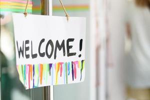 welcome hand written text on paper hanging on cafe door photo