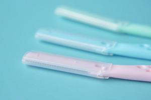 color plastics woman razors and shaving blade on table photo