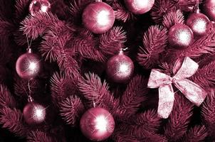 Detailed photo of the Christmas tree. Image toned in Viva Magenta, color of the 2023 year